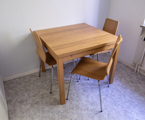 Three chairs and a wooden table in a kitchen.