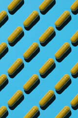 yellow capsules on a blue background with white. Preparation on the topic of medicine and health