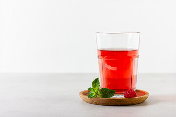 Raspberry drink in the glass on the light background.
