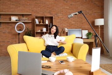 Young Asian woman recording podcast at home
