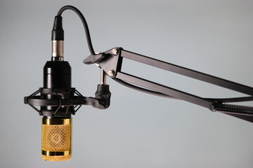Studio microphone for podcast and voice recording on a gray background with space for inscription