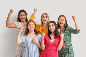 Beautiful young happy women showing muscles on white background. Women history month