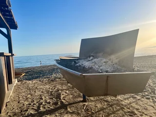 Foto auf Acrylglas Sunset Beach with Ash-Filled Firepit © ivan