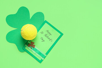 Tennis ball, greeting card and clover on green background. St. Patrick's Day celebration