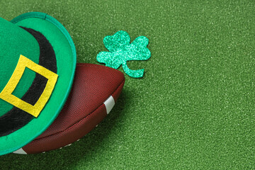 Rugby ball with clover and leprechaun's hat on green grass background. St. Patrick's Day celebration