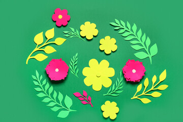 Composition with colorful origami flowers on green background