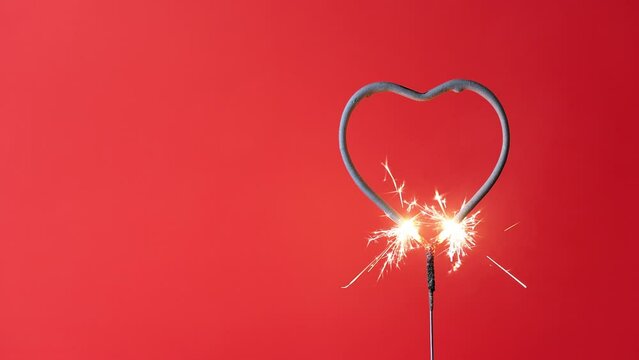 4K video Valentine's Day heart shape sparkler with a red background during the month of February where people get engaged to get married.