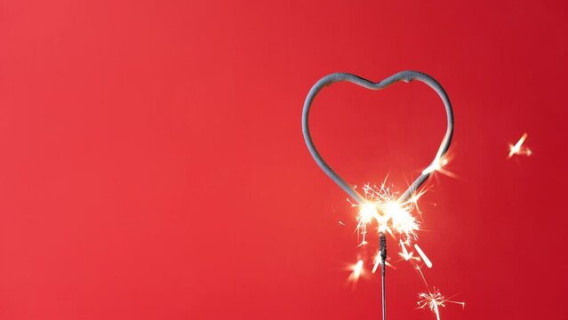 4K video Valentine's Day heart shape sparkler with a red background during the month of February where people get engaged to get married.