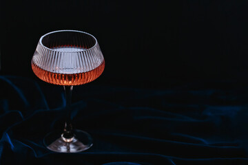 Glass of rose sparkling wine on dark velour background. Beautiful glamorous background for romantic...