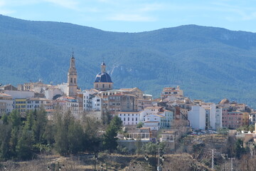 Fototapeta na wymiar Alcoy, Alicante, Spain, February 20, 2024: Bell tower and dome of the Parish of Santa Maria with the forest in the background. Alcoy, Alicante, Spain