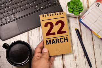 March 22 calendar date text on wooden blocks with blurred park background. Copy space and calendar concept.