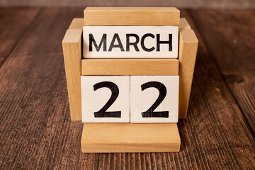 March 22 calendar date text on wooden blocks with blurred park background. Copy space and calendar concept.