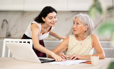 Mature woman consulting with female real estate agent in home interior