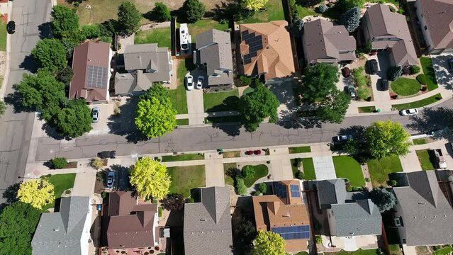 Suburban low density housing single family homes in average middle class neighborhood. Drone shot slowly trucking right down street.