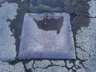 Square metal sewer manhole cover. Rust metal lid.