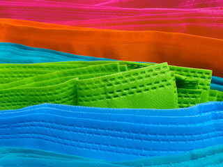 sheets of non-woven fabric in blue, green, orange and oink. pile of colorful non-woven fabric....