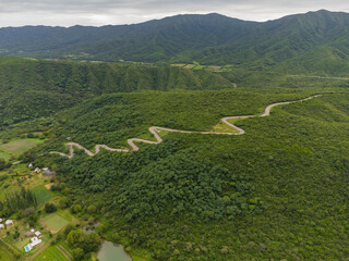 vista aerea desde el dron de un camino zigzagueante con vegetacion alrededor, La Merced, Catamarca, Argentina