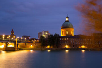 Night view of Hospital de la Grave dome and Saint-Pierre Bridge in Toulouse, France