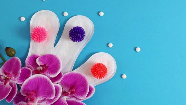Panty liners with virus balls, pills and orchid on blue.