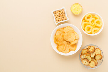 Various unhealthy snacks on color background, top view
