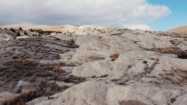 The soft rocks on the slope have been eroded by wind and rain. The camera flies towards the summit.