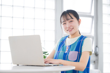 パソコンの作業をする保育士や介護士、スタッフのカメラ目線