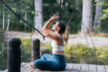 woman meditating in nature near a lake