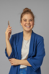 Vertical image of a happy girl with a cell phone in her hands