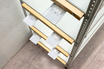 White electrical outlet boxes mounted on metal shelf racks