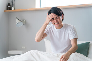 ベッドの上で頭痛・発熱に悩む男性（体調不良・熱・睡眠不足・風邪・コロナ）
 - obrazy, fototapety, plakaty