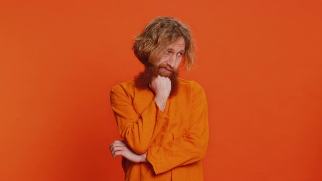 Caucasian man tired bored indifferent expression, exhausted of tedious story, not interested in communication talk, displeasure, uninteresting. Redhead young guy isolated on studio orange background