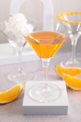 Tasty cocktails in glasses and orange slices on gray table, closeup