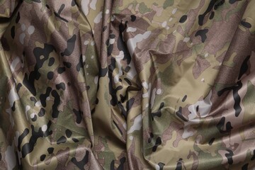 Texture of crumpled camouflage fabric as background, top view