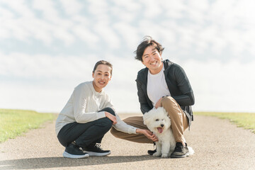 公園で犬の散歩をする愛犬家の夫婦・家族・ファミリー（中年・ミドル）
