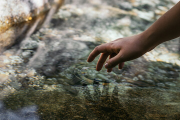 Close-up of a hand in the river water