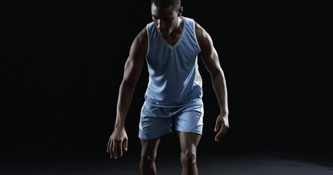 African American basketball player in a focused pose on a black background