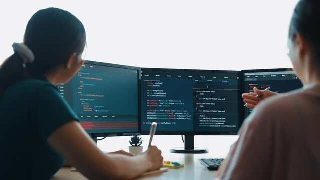 Slow motion back end software developer engineer for computer programming working together on debugging writing computing code, solving complex algorithms display on monitor in office. Burgeoning