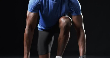 African American athlete in starting position on a black background