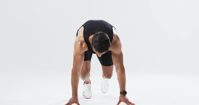 Athlete in starting position on a track on white background