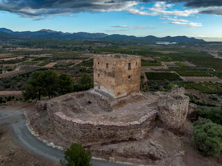 Fototapeta premium Aerial view of Torres Torres medieval castle ruin with square keep and semi circular towers near Valencia Spain with dramatic sky