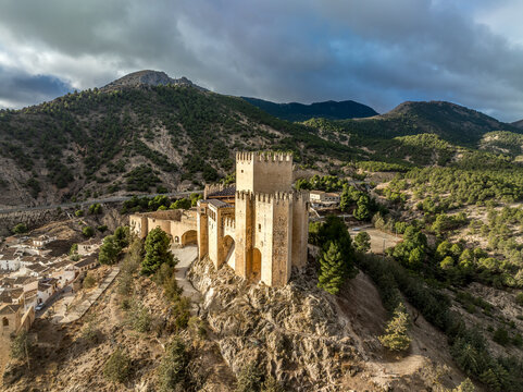 Aerial view of Velez Blanco hilltop medieval castle with square tower, restored Gothic palace above the town with dramatic sky