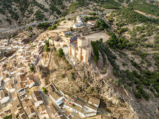 Aerial view of Velez Blanco hilltop medieval castle with square tower, restored Gothic palace above the town with dramatic sky