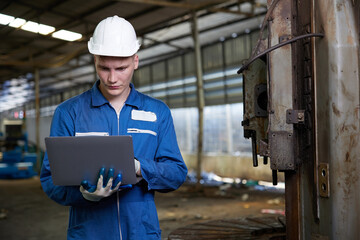 technician or engineer working on laptop computer in the factory