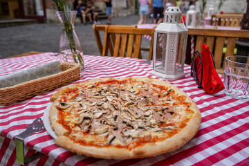 close up large Regina pizza on  arestaurant terrace table