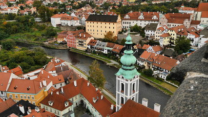 Aerial view of a historic town, river cutting through, colorful buildings with distinct European architecture, cloudy day.