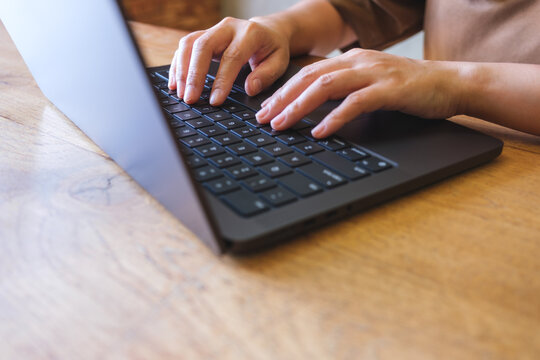 Closeup image of hands working and typing on laptop computer keyboard