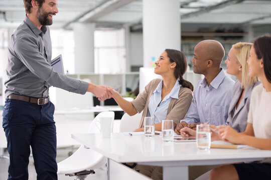 Business, people and handshake for meeting, interview and recruitment process with panel or team in office. Professional employees in human resources and man shaking hands for welcome or introduction