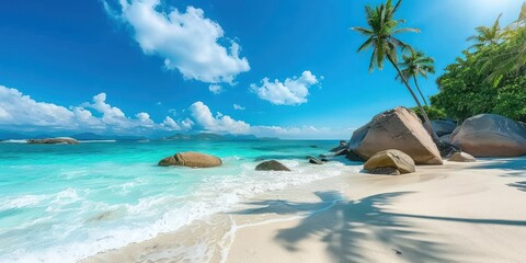 Idyllic tropical beach with white sand, clear turquoise water, granite boulders, and lush palm...