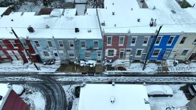 Rundown urban housing covered in snow during winter in USA city. Aerial truck shot. Top down.