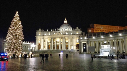 The ornate facade of St. Peter's Basilica at night, illuminated, showcasing architectural details...